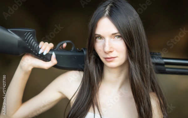 Fototapeta Redhead woman in a suit with a rifle. Special agent.