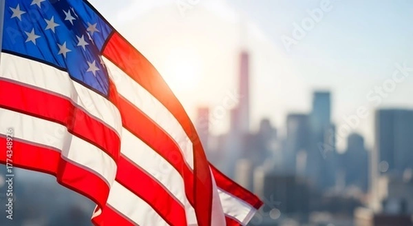 Fototapeta Close up photo of the united states flag waving during the day in bright sunlight with a background of tall buildings