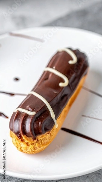 Fototapeta French Chocolate Éclair Pastry with Cream Filling Served on White Plate for Premium Dessert Object and Gourmet Food Concept