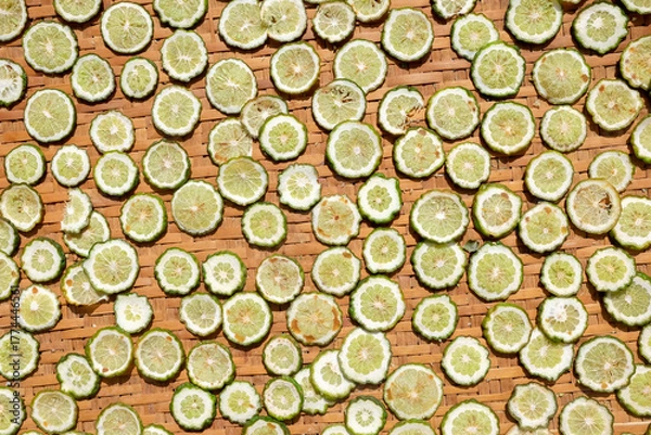 Fototapeta slices of lime on a wooden background, top view.