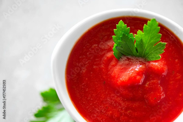 Fototapeta Tomato paste, sauce, Homemade tomato paste in a white bowl and fresh ingredients on a grey table. Ketchup, Red sauce for pizza or pasta made from fresh bio tomatoes. Border design. Top view 