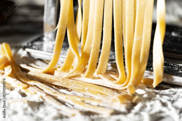 Obraz Fresh raw noodles made on home pasta machine closeup low angle view