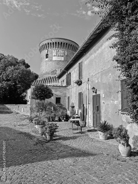 Fototapeta Rome, Italy - July 15, 2025, view of the Borgo di Ostia Antica with a tower of the castle of Julius II.