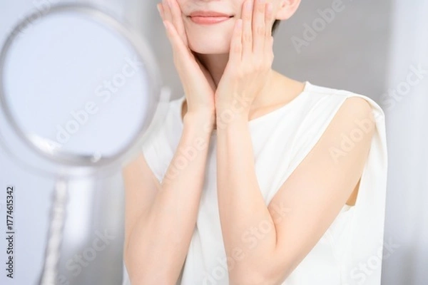 Obraz 鏡を見て肌を確認する日本人女性