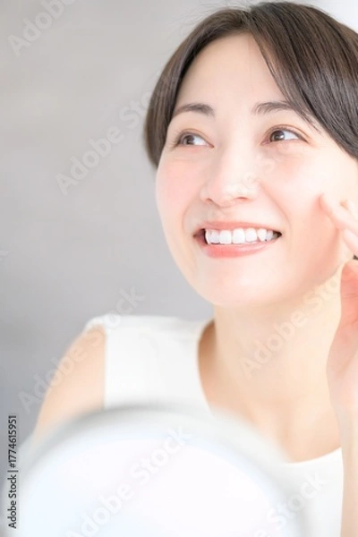 Obraz 鏡を見て肌を確認する日本人女性