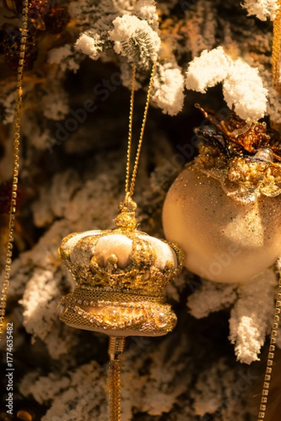 Obraz Golden crown and bauble Christmas ornaments on snowy tree branch