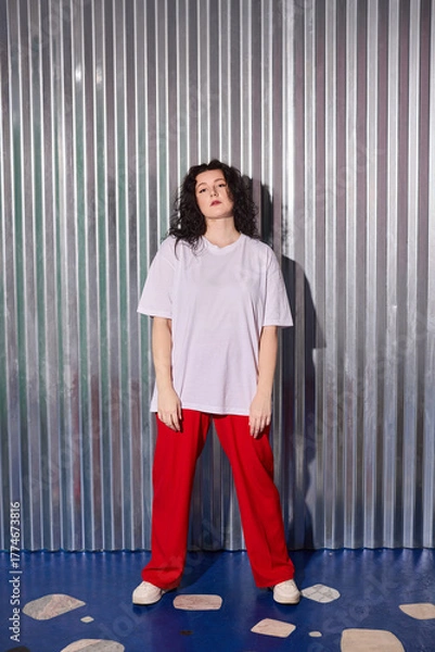 Obraz fashionable woman stands confidently against artistic studio background with sleek styling