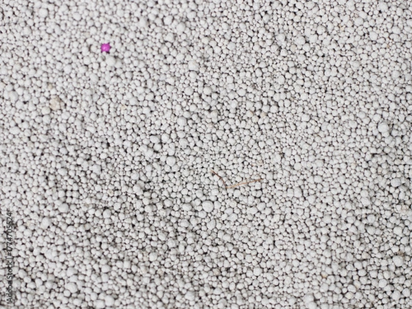 Fototapeta Cat litter granules close up. Granular toilet filler texture. Cat litter in a granular box. Activated carbon. Texture pattern. Clean cat litter in a litter box. Fresh white bentonite background