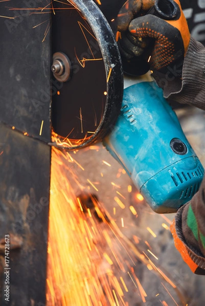 Fototapeta Worker using a cutting disc to cut metal