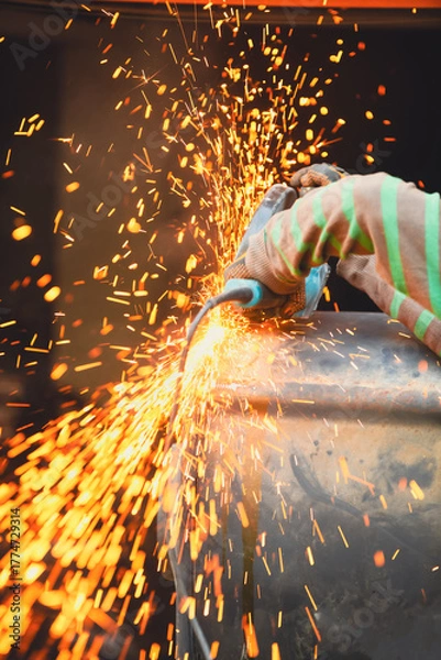 Fototapeta Worker using a cutting disc to cut metal