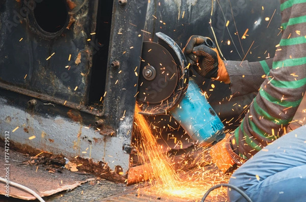 Fototapeta Worker using a cutting disc to cut metal