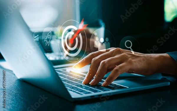 Fototapeta Business goal and digital strategy success concept with businessman typing on laptop computer and futuristic target icon surrounded by growth chart, rocket launch, teamwork innovation for achievement
