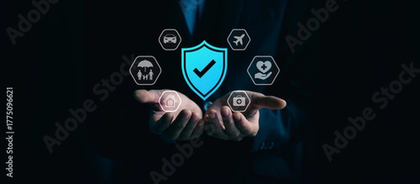 Fototapeta Comprehensive insurance protection and financial security concept with businessman hand holding shield check mark, of home, car, family, travel, health, medical care coverage for safety and stability