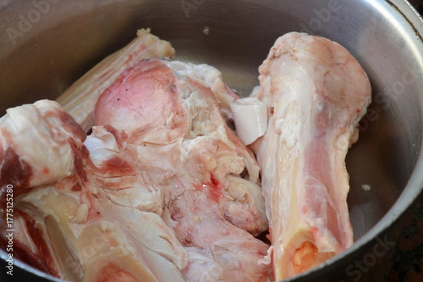 Obraz several pieces of raw beef bones in a pot, being prepared for making bone broth, bone marrow soup or stock, Bone broth is a nutrient-dense liquid made by simmering animal bones in water