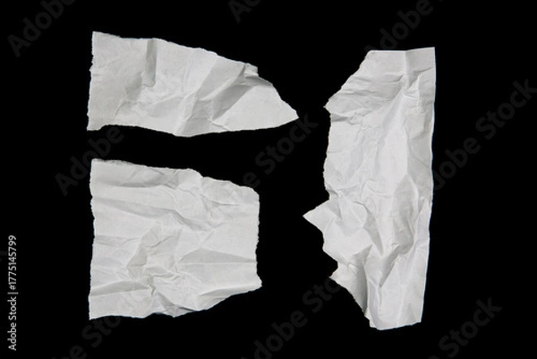 Fototapeta White paper cut with torn edges isolated on black background.