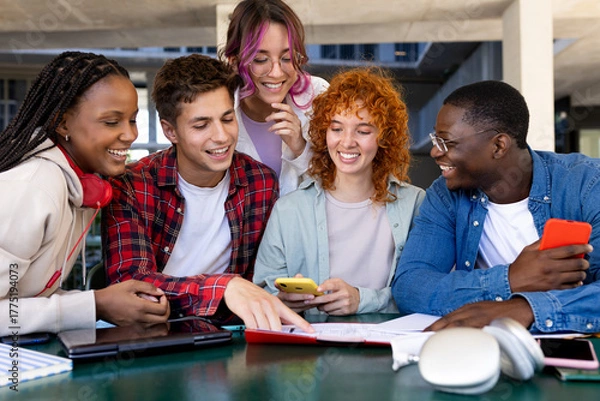 Obraz Group of cheerful diverse students working together on a project at university campus