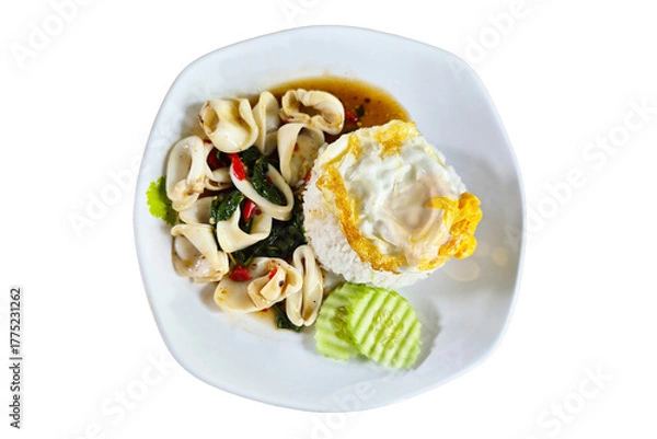 Fototapeta Thai traditional dish of stir-fried squid with basil leaves, chili, and garlic, served with jasmine rice and fried egg on a white plate.