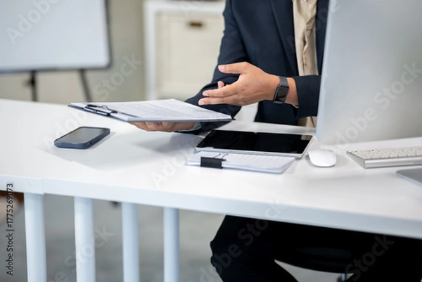 Obraz Male office worker checking documents on computer desk in office