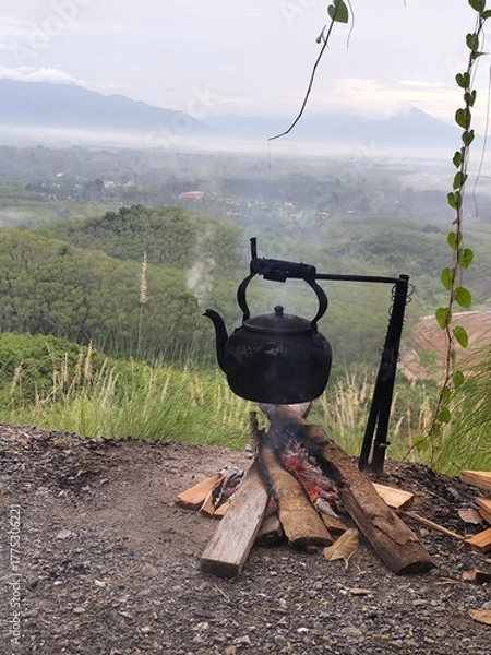 Fototapeta The kettle image shows boiling water and smoke rising from the wood.
