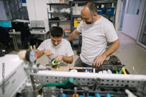 Obraz Orthopedic specialists assembling artificial limb together