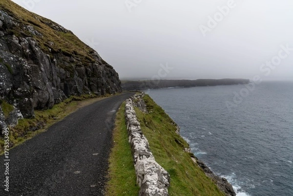 Obraz narrow single-lane road leading along steep cliffs from Sanduk to Soltavik on the Faroese Island of Sandoy