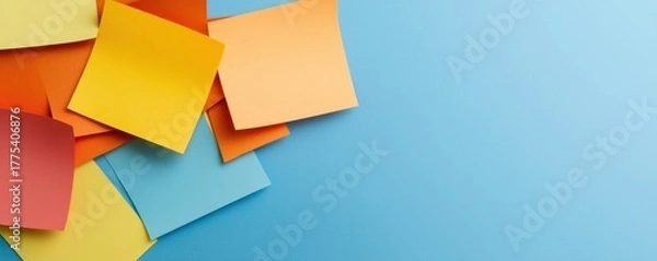 Fototapeta Colorful sticky notes scattered on a blue background, ideal for reminders and organization.