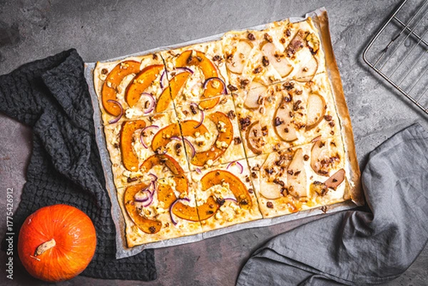 Fototapeta Tarte flambee with pumpkin, red onions, sheep's cheese and walnuts on a gray background