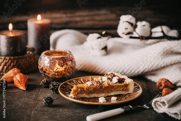 Fototapeta Piece of pumpkin pie with nuts and cranberries on a wooden table
