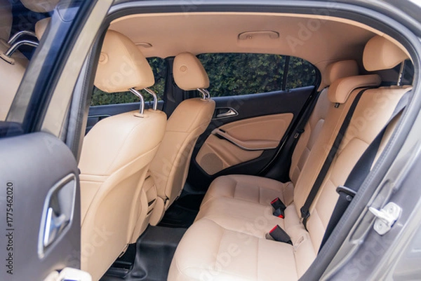 Fototapeta Photograph showing the interior of a modern vehicle from the rear with beige leather seats