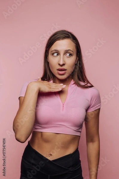 Fototapeta Woman in pink top looking surprised against pink background