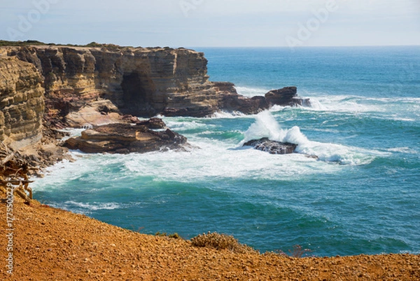 Fototapeta West Algarvve coast with steep cliffs and breaking waves. Portugal