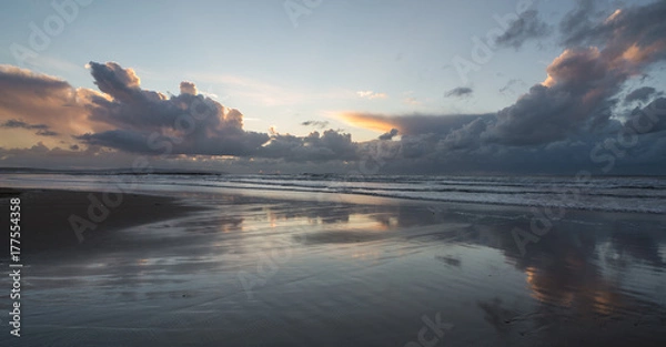 Fototapeta Stormy skies in the distance of west coast beach in Ireland at sunset