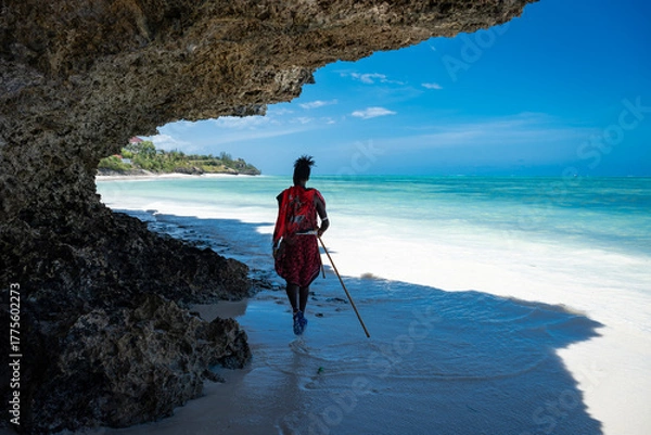 Obraz A Masai man walks along a beautiful Indian Ocean beach.
