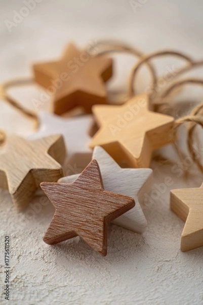Fototapeta A close-up of rustic wooden and painted paper star-shaped Christmas ornaments arranged on a textured surface with natural jute twine loops for hanging