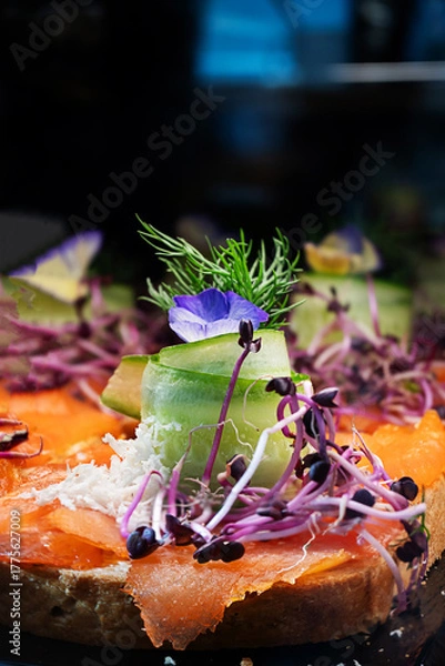 Fototapeta Smorrebrod open sandwich on rye bread, topped with salmon, traditional Danish lunch.