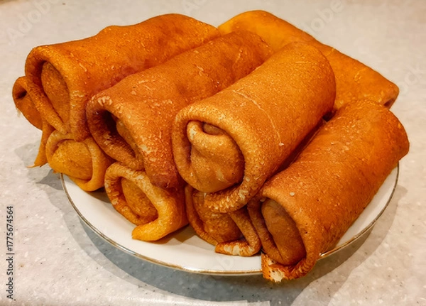 Fototapeta A plate of pancakes sits on the table.