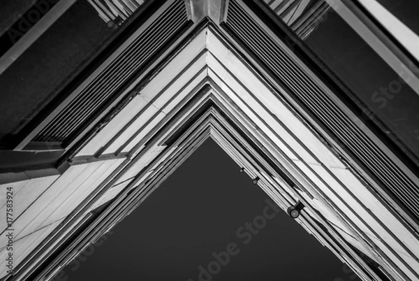 Fototapeta Urban Geometry, looking up to building. Modern architecture black and white, concrete and glass.  Abstract architectural design. Inspirational. Artistic image and point of view.