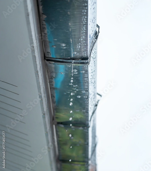 Obraz Leaking galvanized roof gutter joint with water dripping from worn-out seal