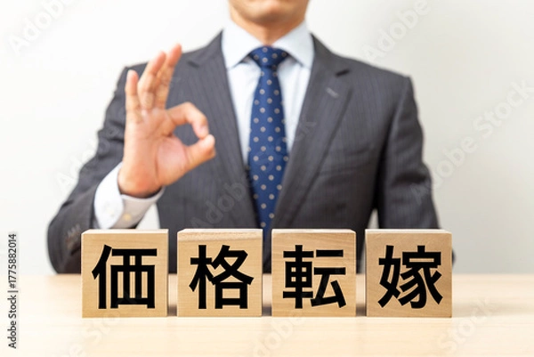 Fototapeta 「価格転嫁」と書かれたブロックとOKポーズをするビジネスマン