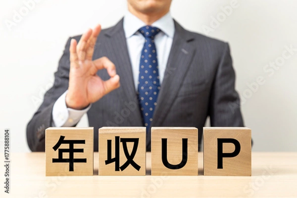 Obraz 「年収UP」と書かれたブロックとOKポーズをするビジネスマン