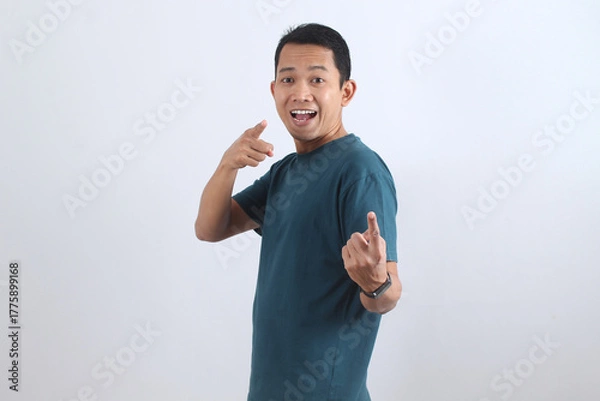 Obraz Happy Asian man pointing finger at camera, choosing you. Excited male model smiling.