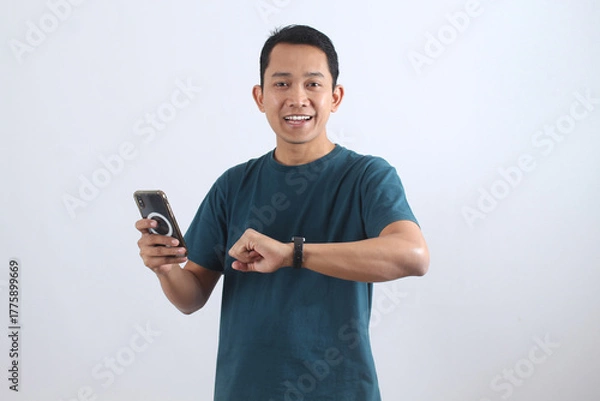 Obraz Smiling Asian man using smartwatch and smartphone technology