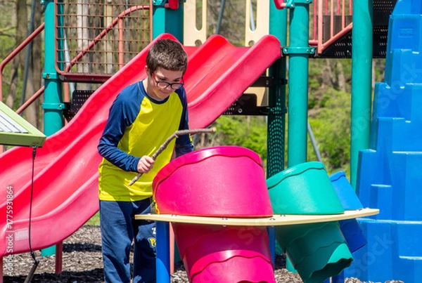 Obraz  Young boy Playing with drums at a play ground