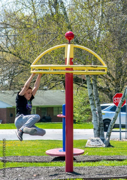 Obraz boy hanging from swinging merry go round