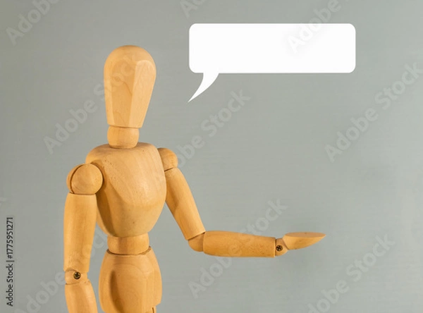 Obraz Wooden mannequin gesturing with hand extended and speech bubble on gray background