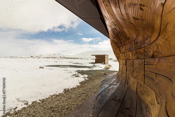 Obraz Part of the building viewpoint Snohetta, with small hut in background, winter and snow, blue sky and clouds