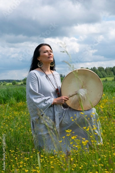 Fototapeta Portrait of a middle-aged shaman woman among yellow flowers