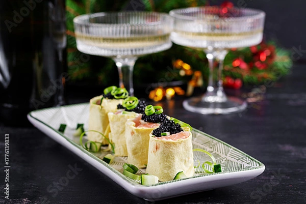 Obraz Canapes appetizer with salmon and black caviar on the Christmas table. Canapes with fish and caviar.