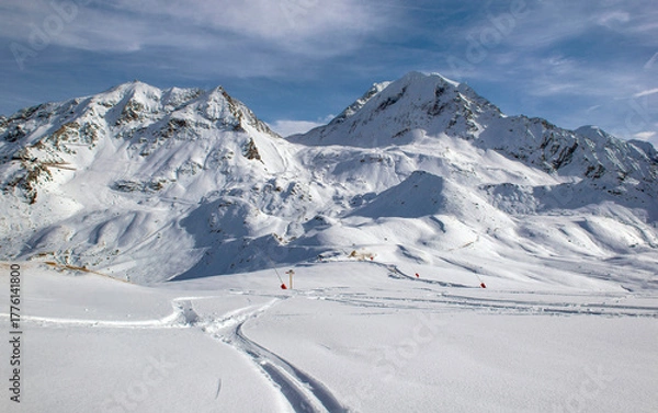 Fototapeta trace of ski touring in the freshly fallen snow on the ski slopes with snowy peak mountain background