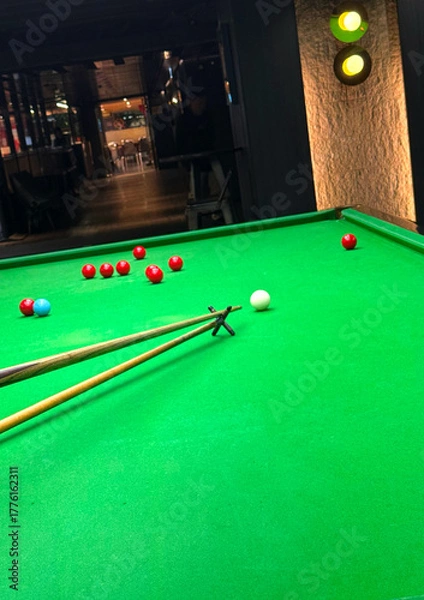 Obraz Snooker balls, cue extension stick and green table in indoor  room